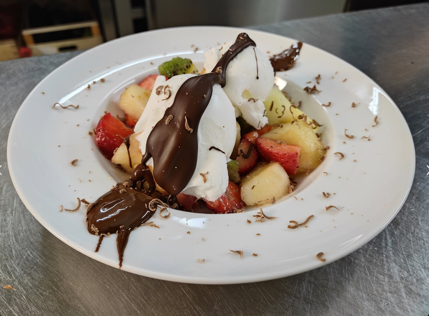 Frutta fresca con panna e cioccolato fondente.